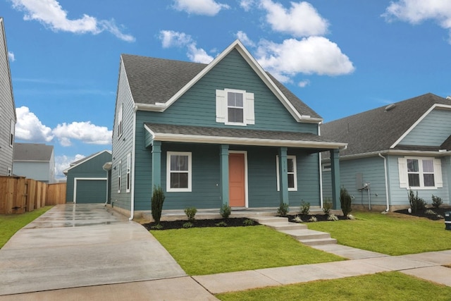 view of front of home featuring a garage, an outdoor structure, a front yard, and covered porch