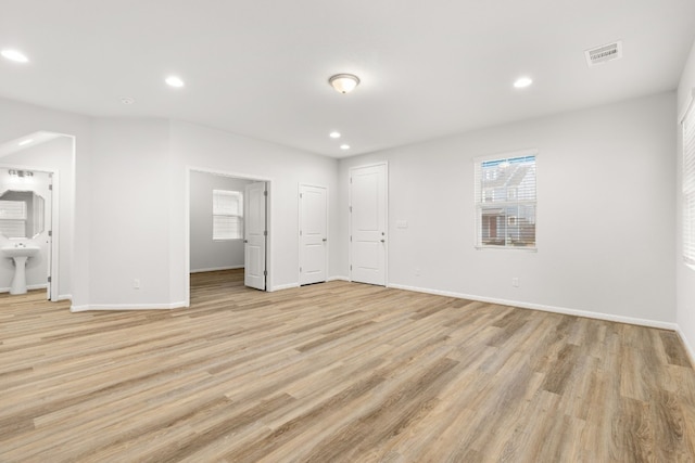 unfurnished bedroom with ensuite bath and light hardwood / wood-style floors