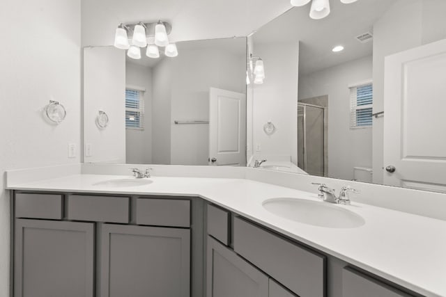 bathroom with vanity, an enclosed shower, and toilet