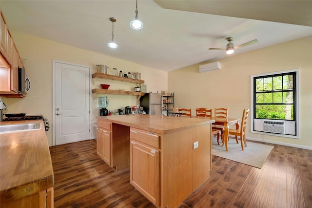 1137 Loop 163 Loop, Blanco, TX 78606 - kitchen with a wall mounted AC, stainless steel appliances, a kitchen island, dark wood-type flooring, and a ceiling fan