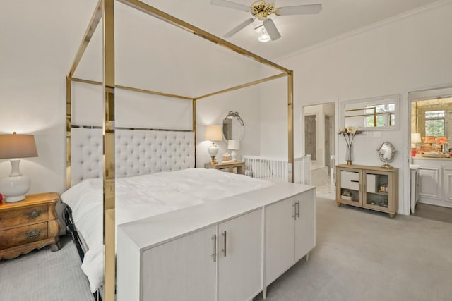 bedroom featuring light colored carpet, ensuite bath, ceiling fan, and ornamental molding