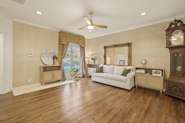 living area with baseboards, crown molding, a ceiling fan, and wood finished floors