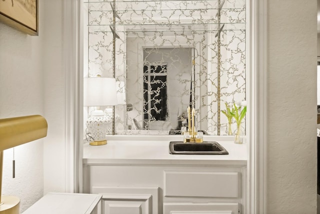 bathroom with vanity and a textured wall