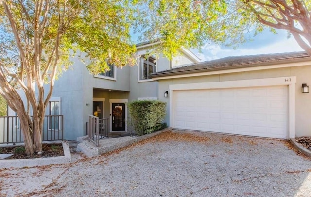 view of front of home with a garage, driveway, and stucco siding