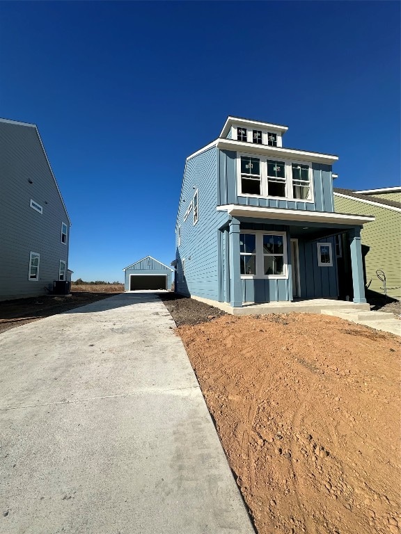 view of front facade featuring an outbuilding, a garage, and central air condition unit