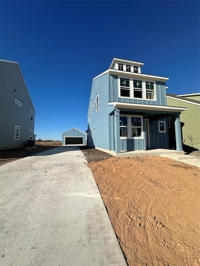 view of front of house with central AC, board and batten siding, and an outdoor structure