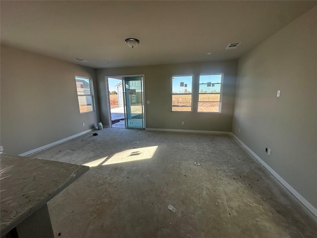 unfurnished room featuring plenty of natural light, baseboards, and visible vents