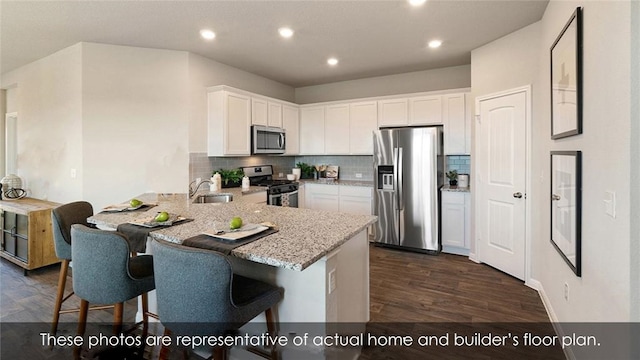 kitchen featuring white cabinetry, dark hardwood / wood-style flooring, kitchen peninsula, and appliances with stainless steel finishes