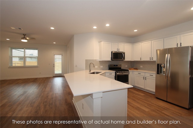 kitchen with ceiling fan, sink, stainless steel appliances, dark hardwood / wood-style flooring, and kitchen peninsula