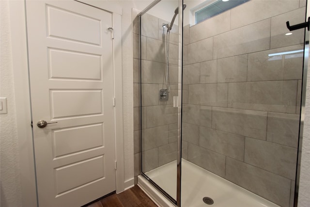 bathroom featuring hardwood / wood-style floors and a shower with door