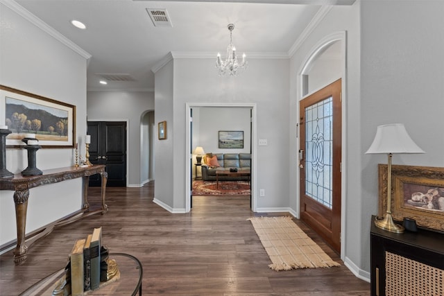 foyer entrance with a notable chandelier, dark hardwood / wood-style floors, and ornamental molding