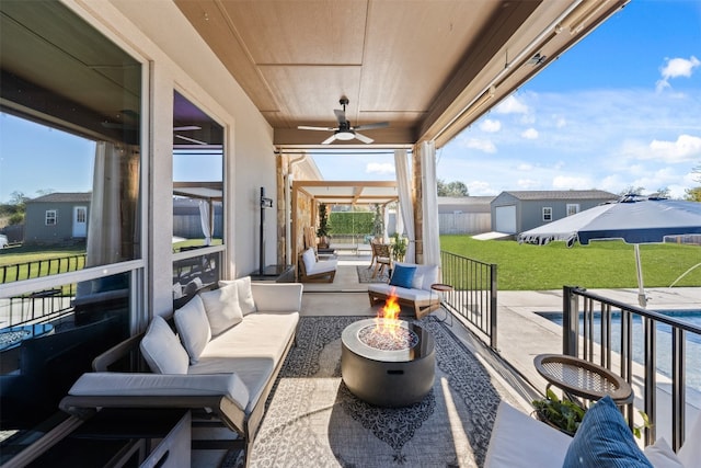 view of patio / terrace with ceiling fan and an outdoor living space with a fire pit