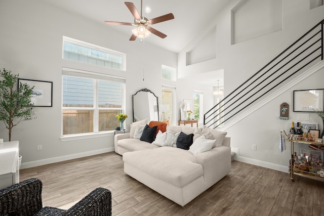 living room featuring plenty of natural light, ceiling fan, high vaulted ceiling, and light hardwood / wood-style flooring