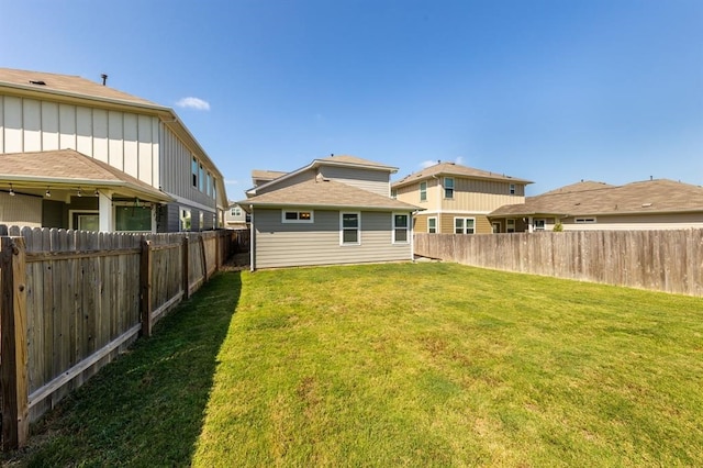 back of house featuring a yard and a fenced backyard