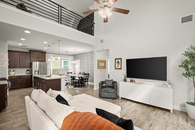 living area with light wood-style flooring, recessed lighting, visible vents, and baseboards