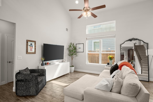 living room featuring ceiling fan, high vaulted ceiling, and wood-type flooring