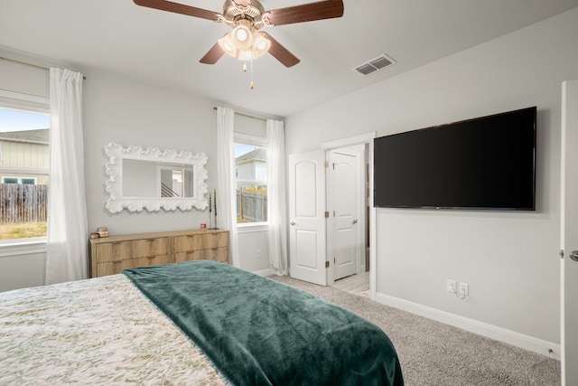 bedroom with light colored carpet, visible vents, baseboards, and multiple windows