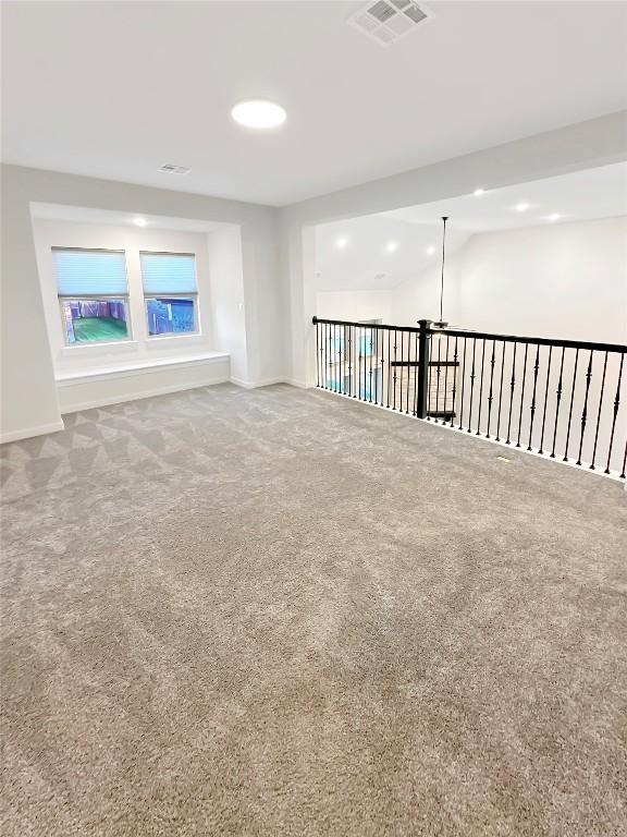 empty room featuring carpet floors, visible vents, and baseboards