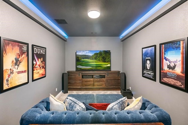 home theater room featuring carpet, visible vents, and a textured ceiling