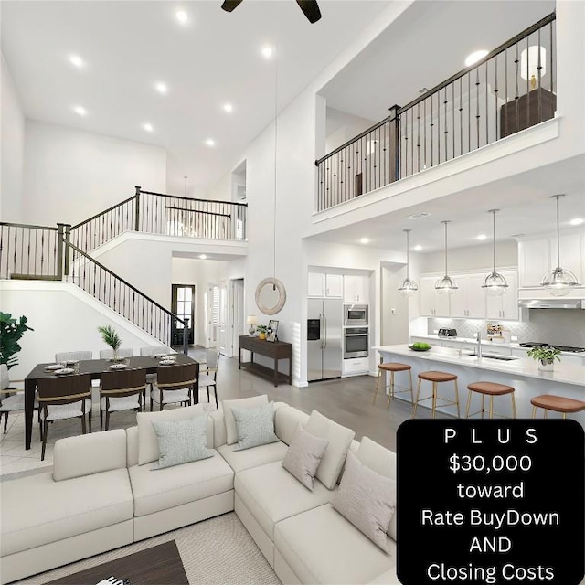 living room with a high ceiling, ceiling fan, and sink