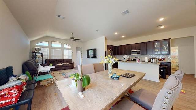 dining space with lofted ceiling, ceiling fan, and light hardwood / wood-style flooring