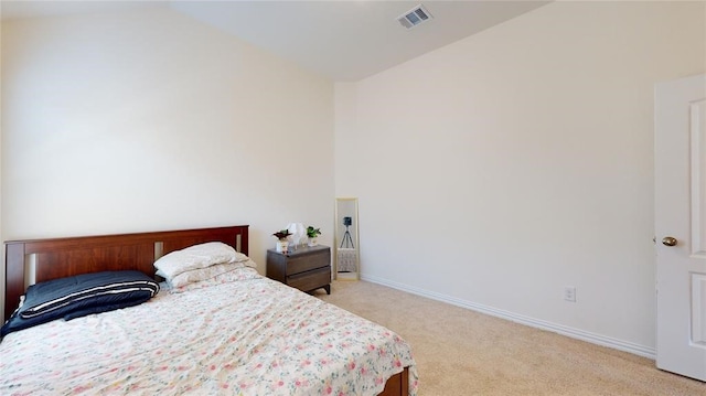 bedroom with light colored carpet and vaulted ceiling