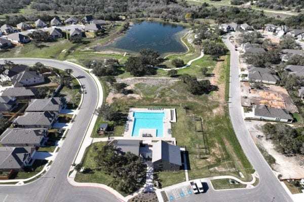 view of property location featuring a pool area, nearby suburban area, and a nearby body of water