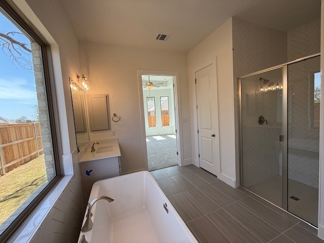 full bathroom featuring a shower stall, a tub to relax in, ceiling fan, and vanity