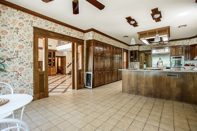 kitchen featuring crown molding, dark brown cabinets, light tile patterned floors, and stainless steel appliances