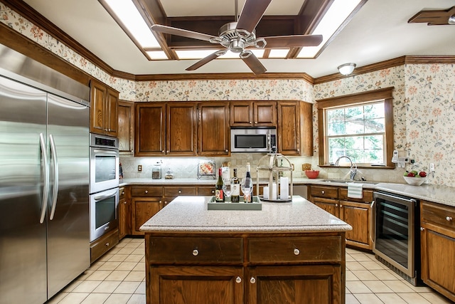 kitchen featuring a kitchen island, sink, stainless steel appliances, and beverage cooler