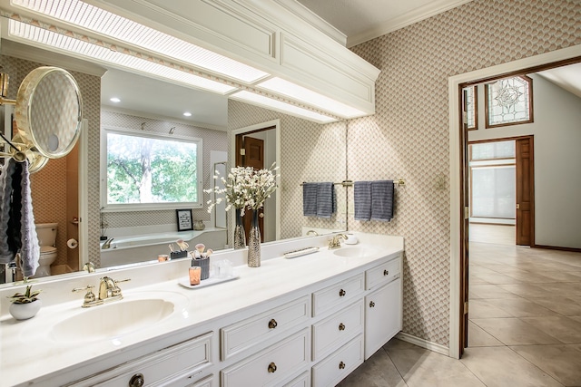 bathroom with a bathtub, ornamental molding, vanity, tile patterned flooring, and toilet