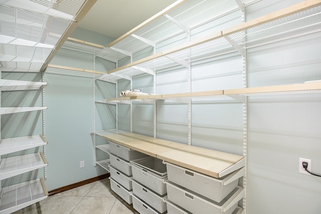 walk in closet with light tile patterned floors