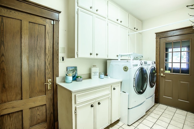 washroom featuring cabinets, washing machine and dryer, and light tile patterned flooring