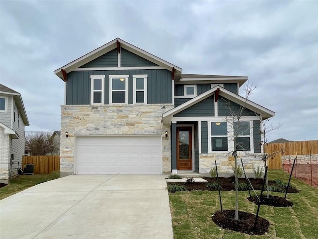 view of front of property featuring central AC, a front yard, and a garage