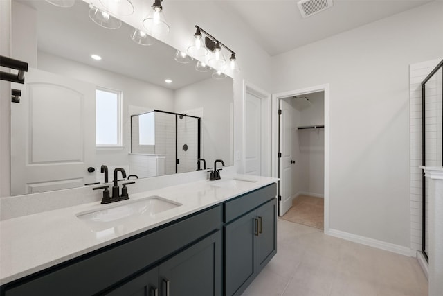 bathroom with tile patterned flooring, vanity, and walk in shower