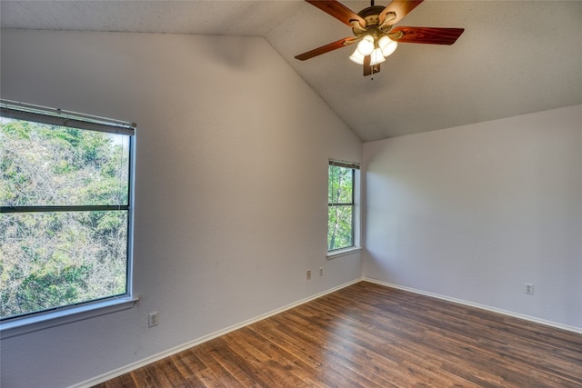 spare room with a textured ceiling, ceiling fan, dark wood-type flooring, and vaulted ceiling