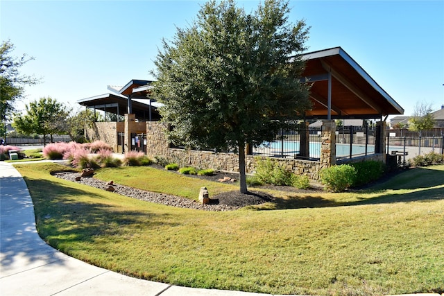 view of home's community with a pool and a lawn