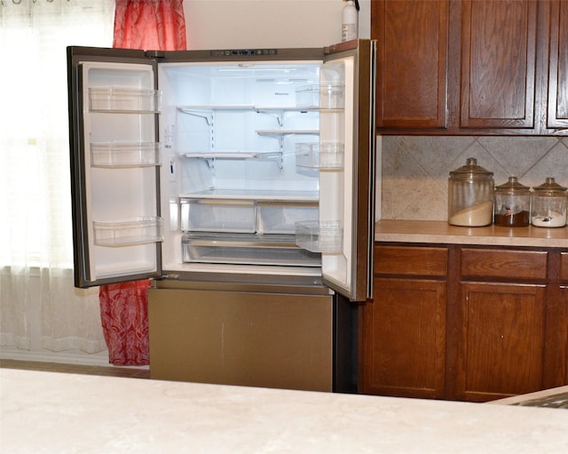 kitchen featuring stainless steel fridge and decorative backsplash