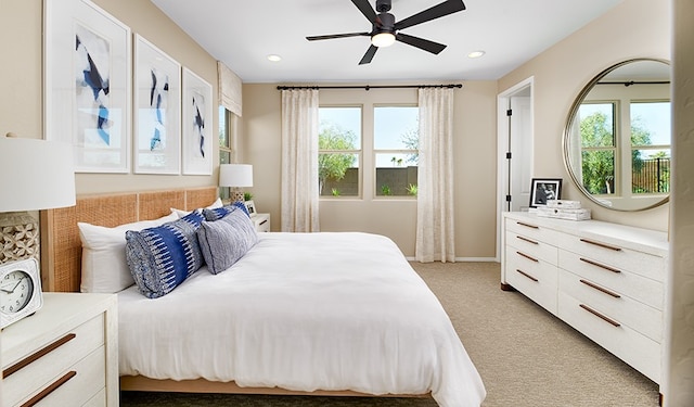 carpeted bedroom featuring ceiling fan and multiple windows