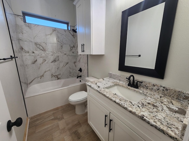 full bathroom with vanity, toilet, hardwood / wood-style floors, and tiled shower / bath combo