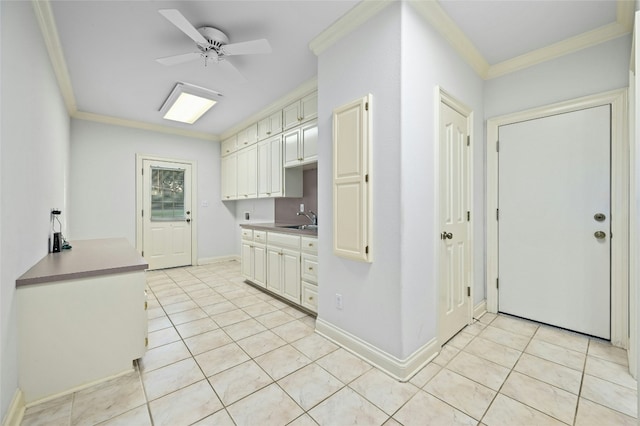 kitchen with light tile patterned flooring, ceiling fan, crown molding, and sink