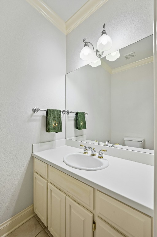 bathroom featuring tile patterned floors, vanity, toilet, and ornamental molding