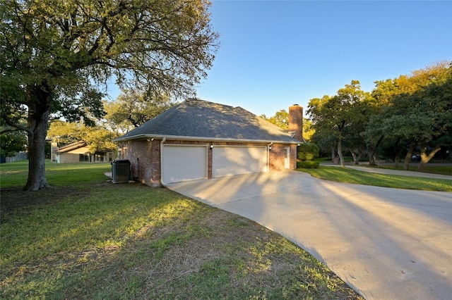 view of side of property with a lawn, central air condition unit, and a garage