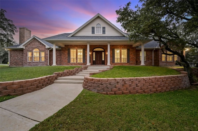 view of front of property featuring covered porch and a yard