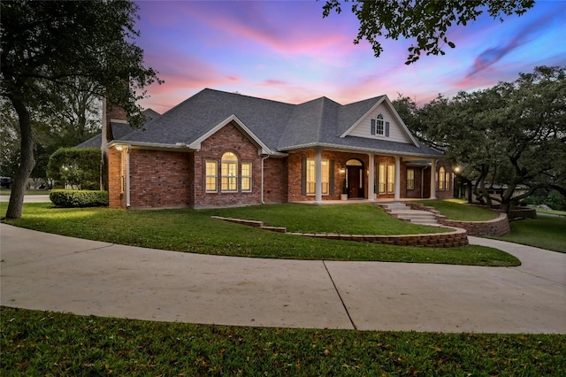 view of front of home with a porch and a yard