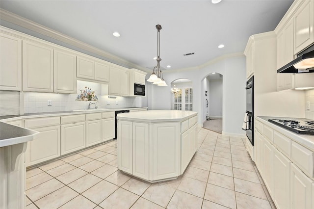 kitchen with light tile patterned floors, decorative backsplash, a kitchen island, black appliances, and ornamental molding