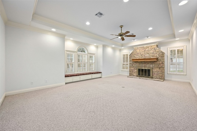 unfurnished living room featuring a fireplace, carpet, a tray ceiling, and crown molding