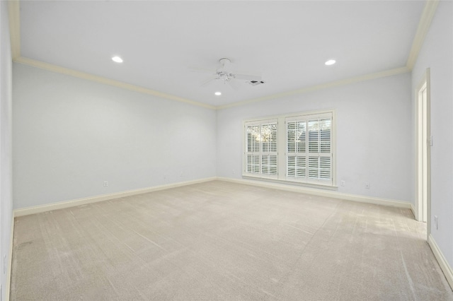 carpeted spare room with ceiling fan and ornamental molding