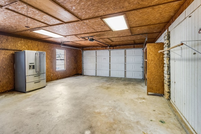 garage with stainless steel fridge with ice dispenser