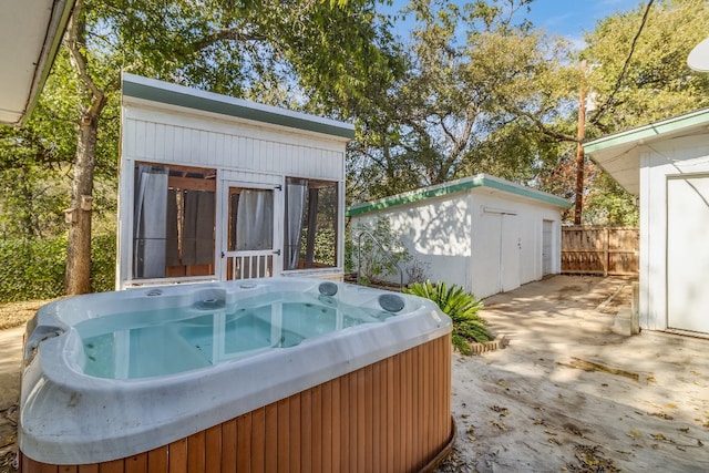 view of patio with a storage unit and a hot tub